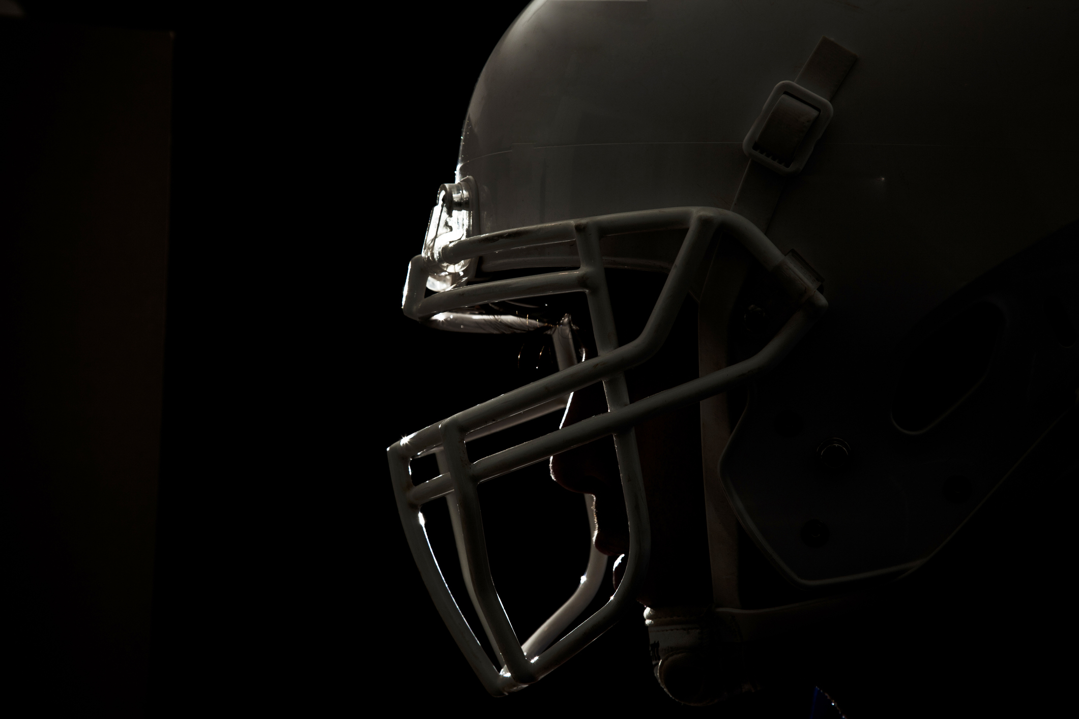 Closeup of side of a football helmet on a black background