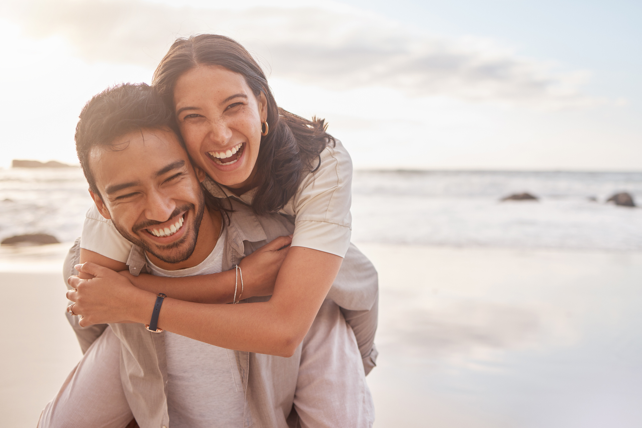 Shot of a couple enjoying a day at the beach after their wedding