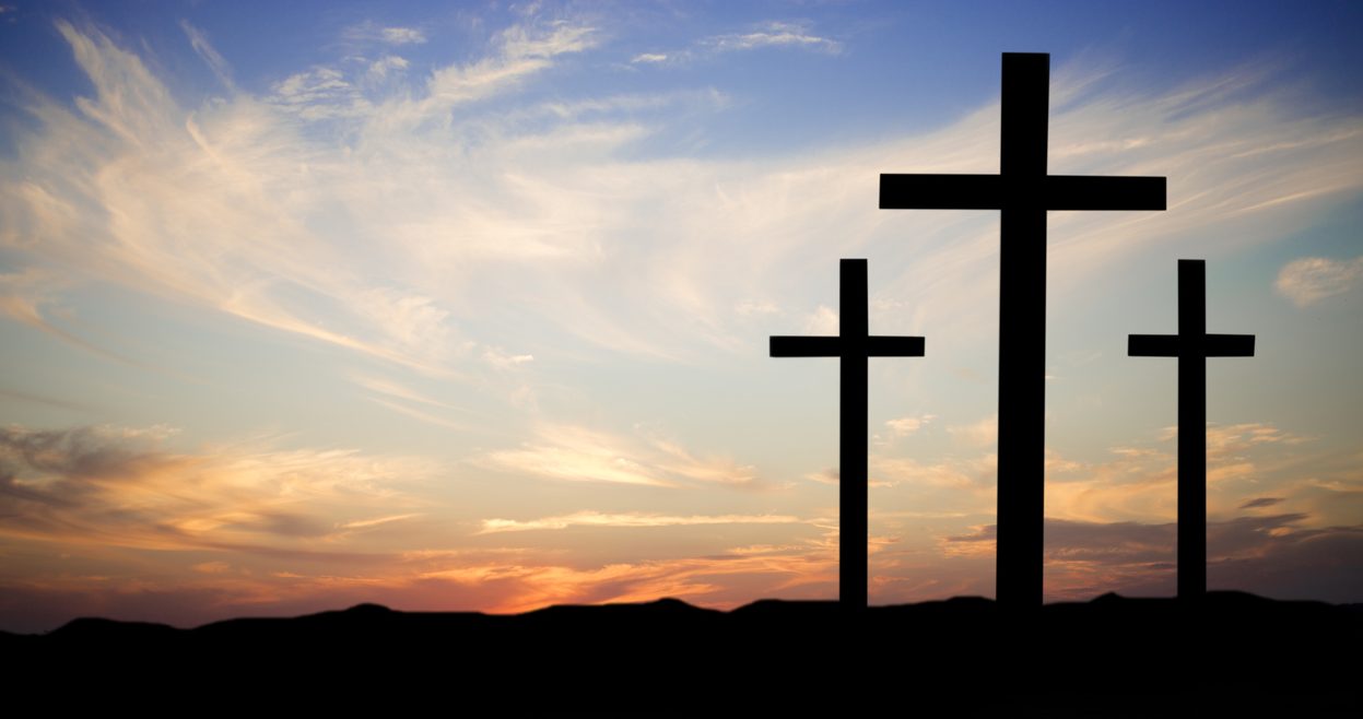 Three crosses against the background of the setting sun