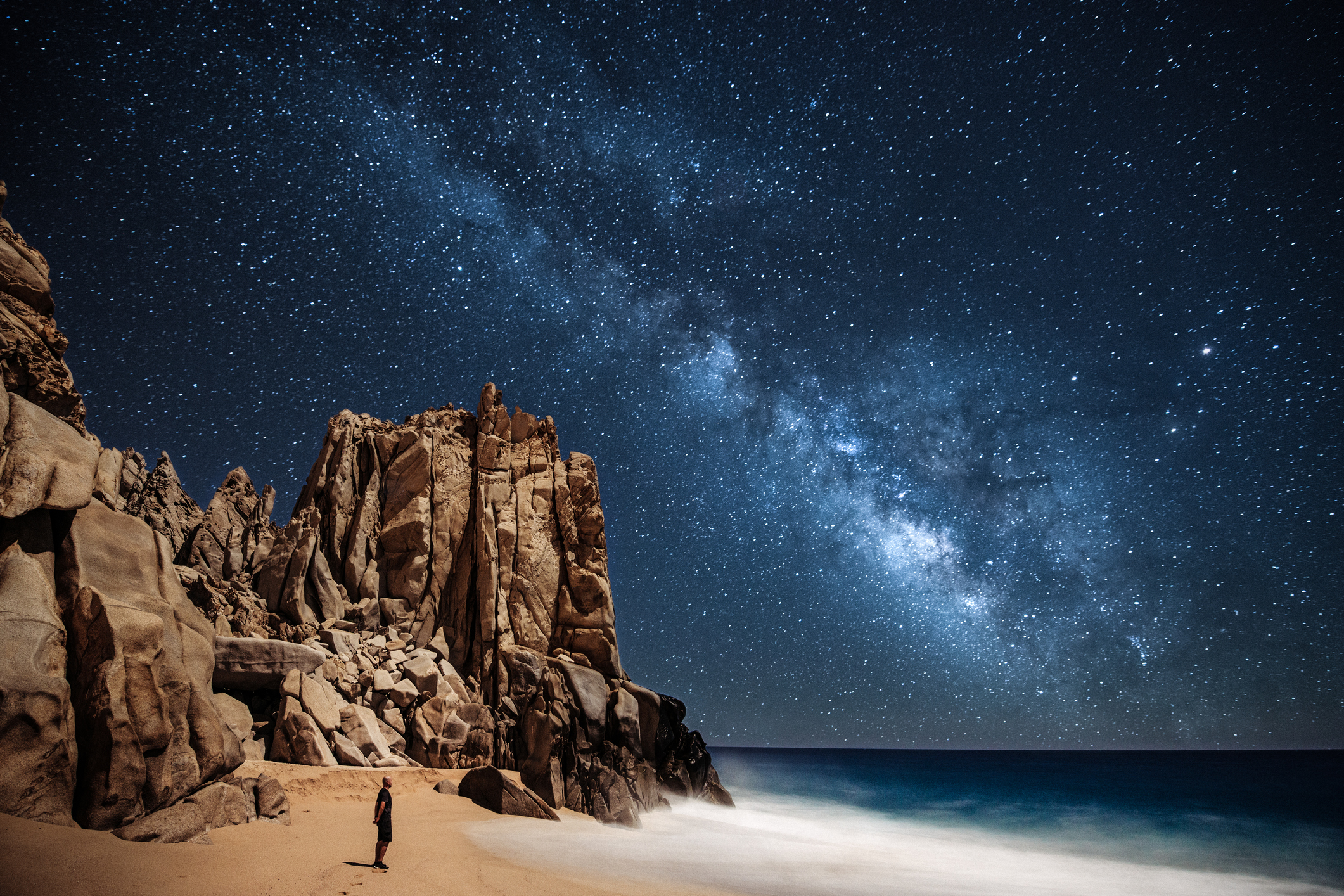 Lone person stargazing by the ocean in Cabo San Lucas