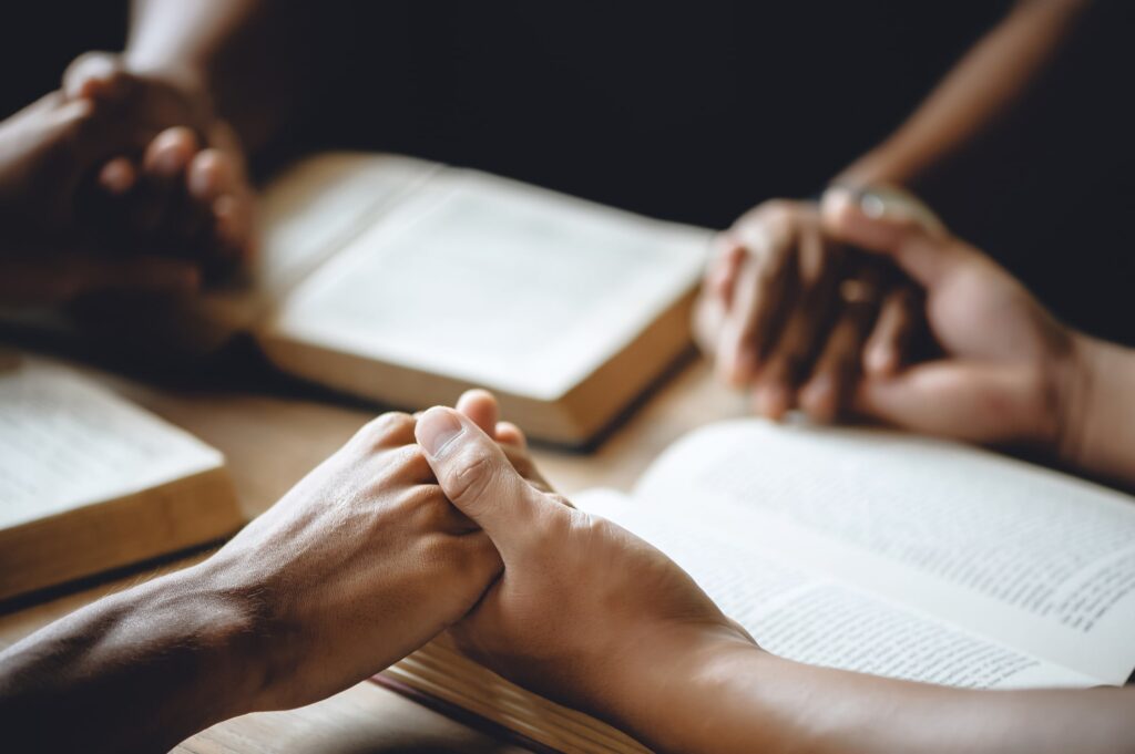 People holding hands over books