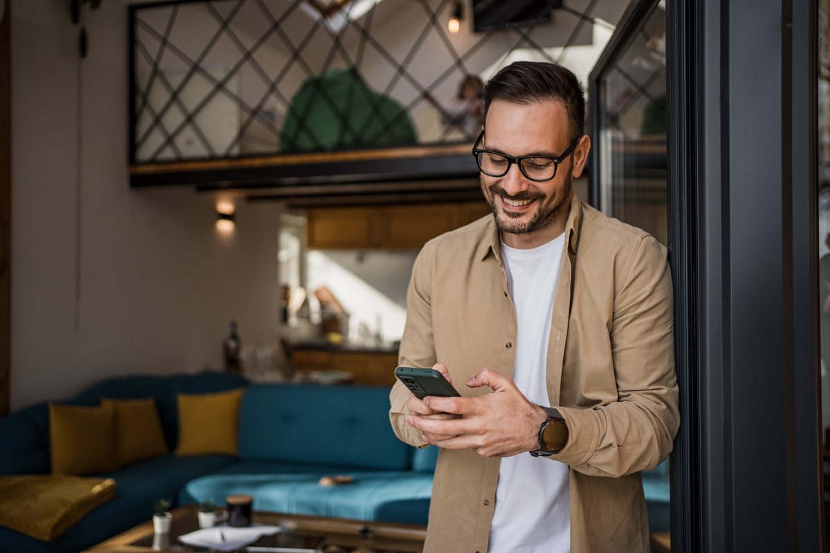 A smiling man looking at the phone